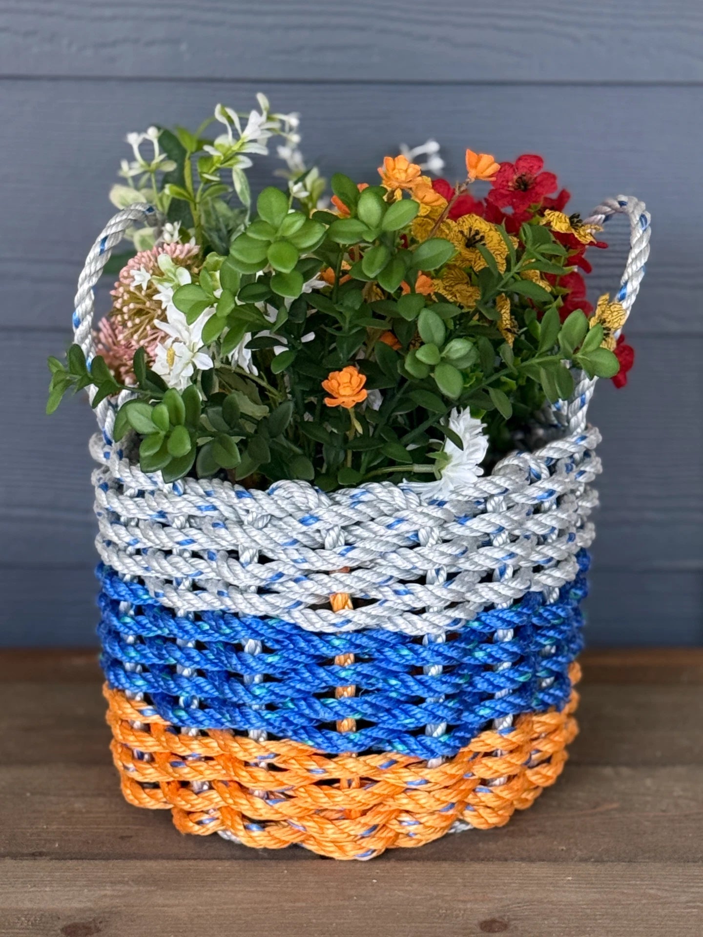Colorful woven basket with flowers against a gray background