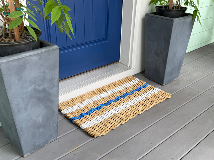 Lolli's Classic+ Blue doormat in front of blue door