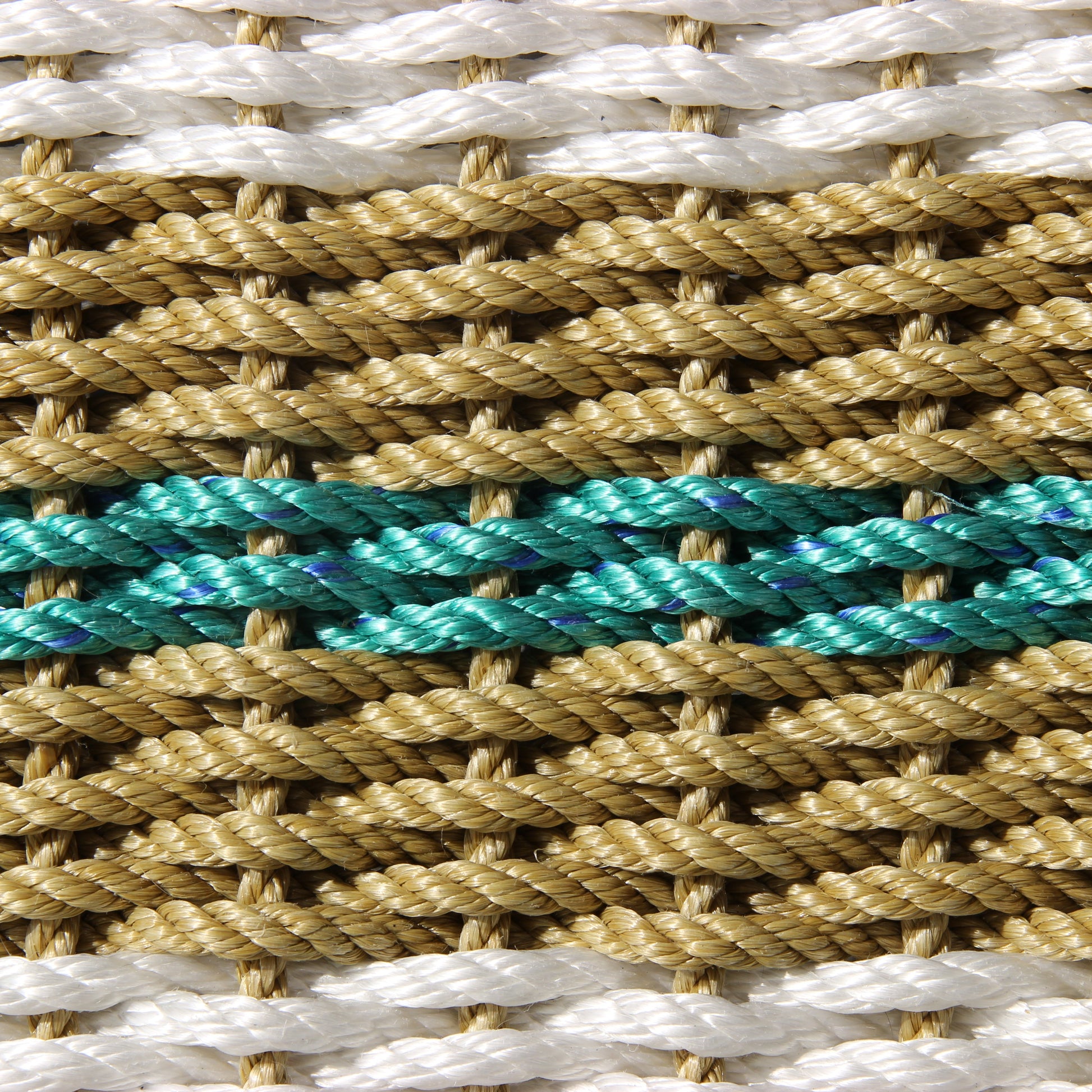 Close-up of handcrafted braided rope with white, tan, and teal strands.