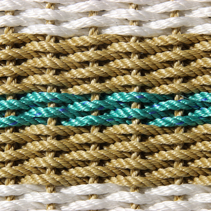Close-up of handcrafted braided rope with white, tan, and teal strands.