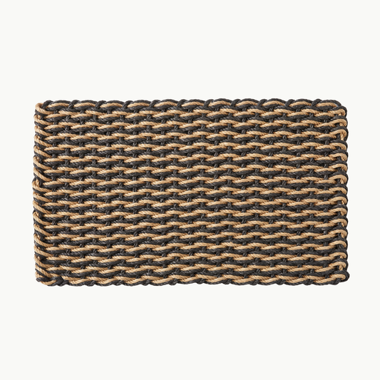 A rectangular woven mat with a double weave pattern of black and natural tan fibers, shown flat against a light off-white background.